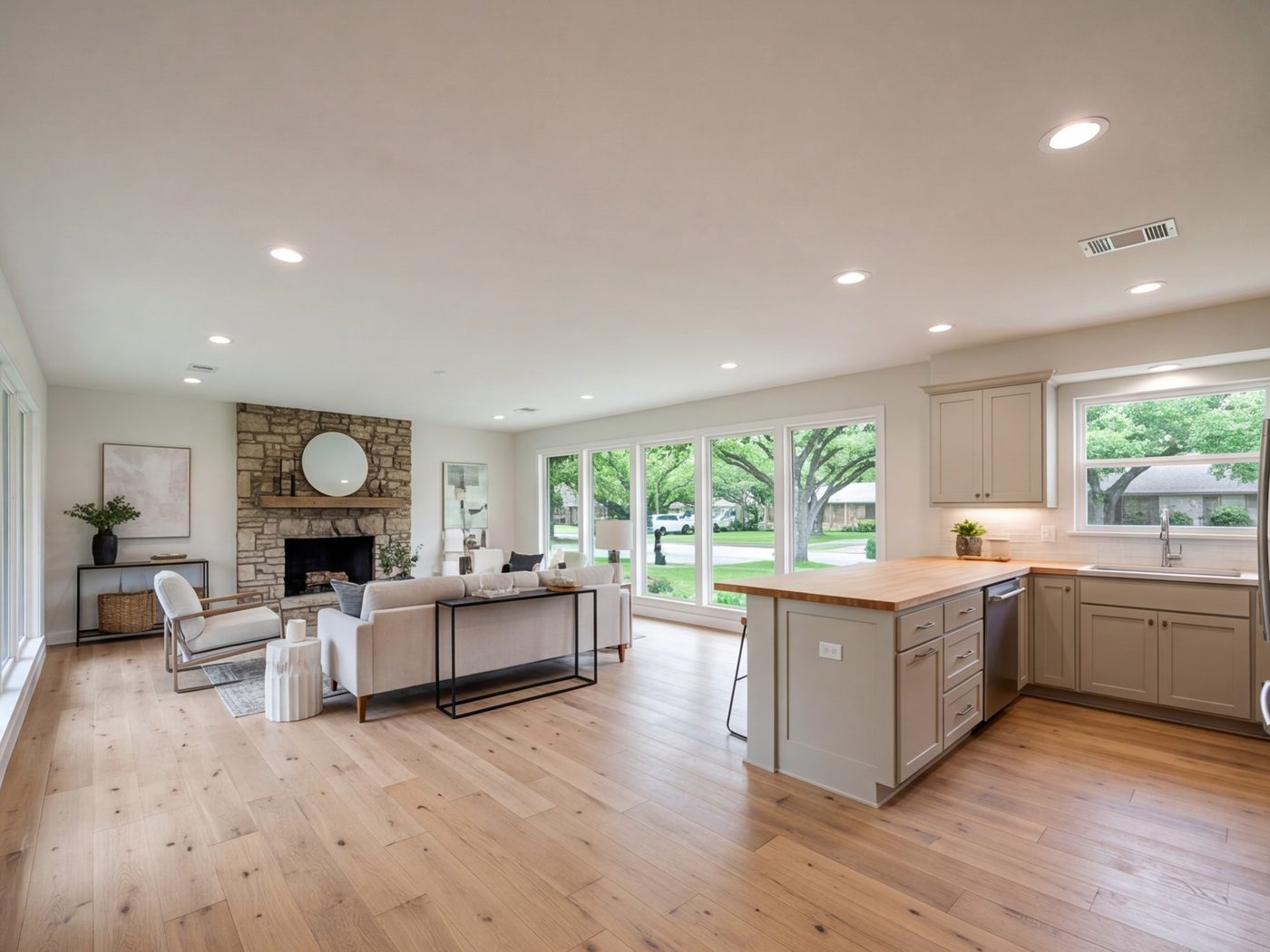 Wide living area and kitchen in an updated 1970s ranch house with new floors